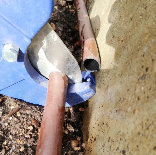 Cutting out a damaged section of drip line with PVC cutters