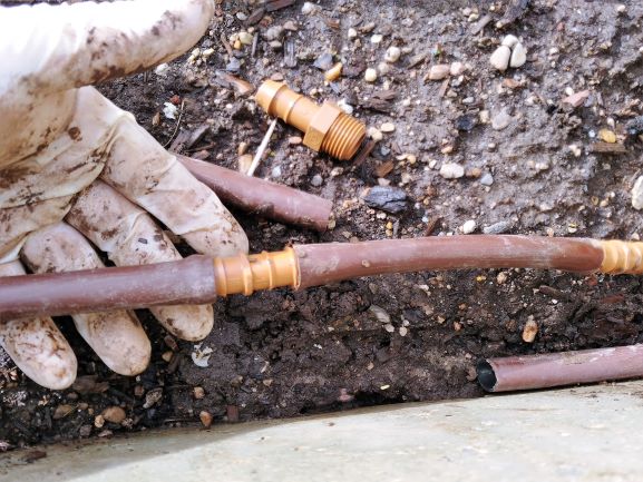 Inserting a repair piece into the broken drip line