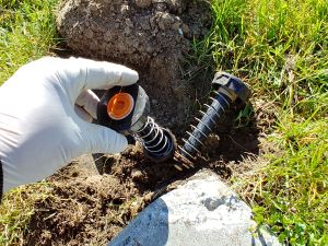 Inserting the new guts into the old sprinkler head pop up body